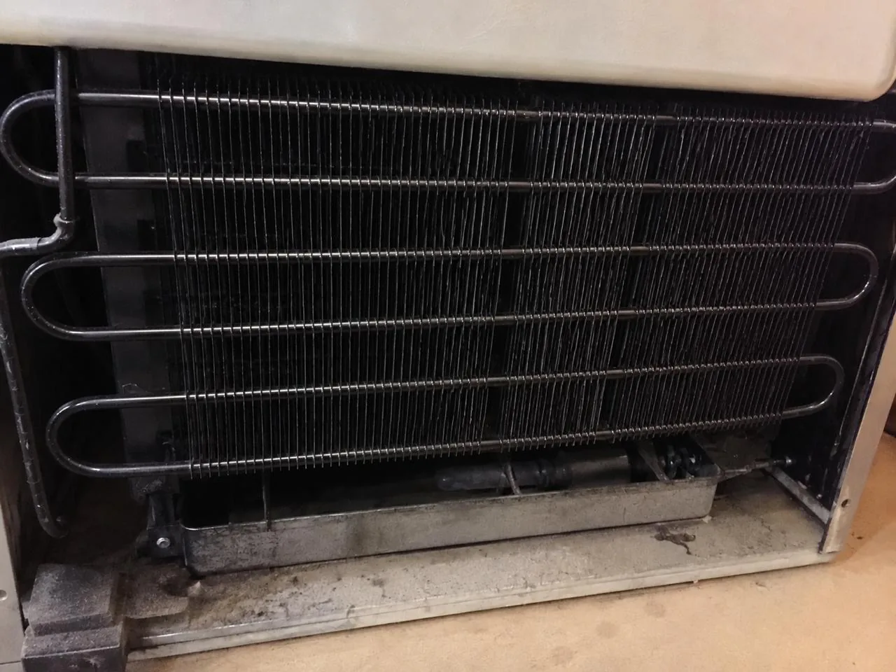 The same refrigerator condenser coils brushed clean after service
