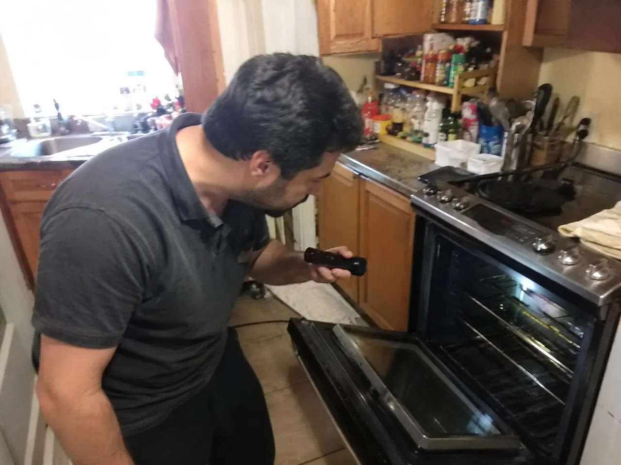 Technician repairing an open oven and range